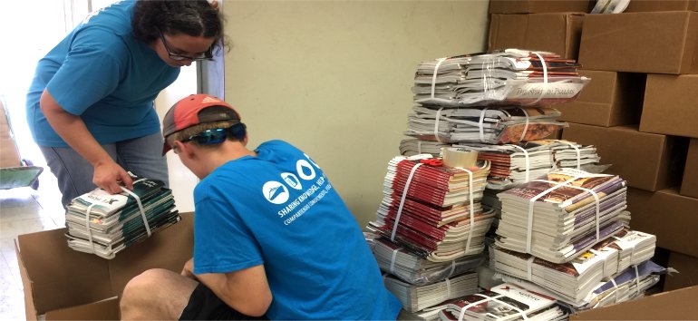 Logos Hope volunteers pack Love Packages shipped to Barbados for the churches of Dominica donated by Eagles Nest Ministries